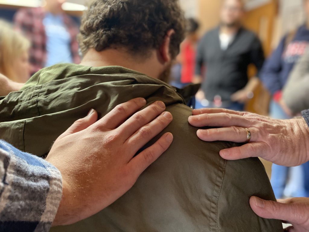 People praying over a man